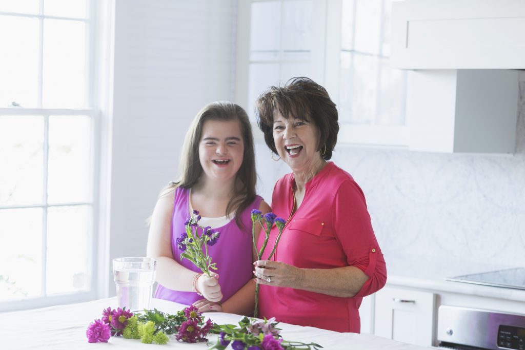 Girl with down syndrome, grandmother arranging flowers